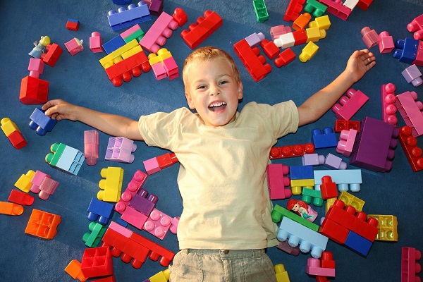 A boy laying on the ground with legos