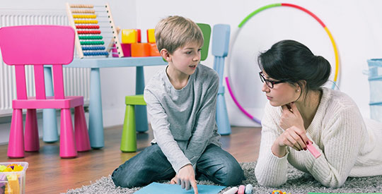 A woman and boy sitting on the floor